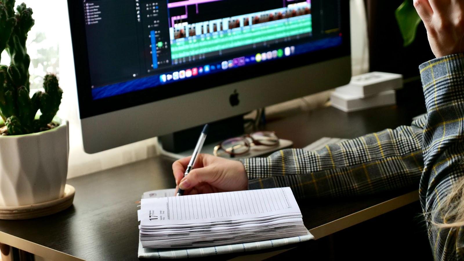 editing software on screen as editor takes notes